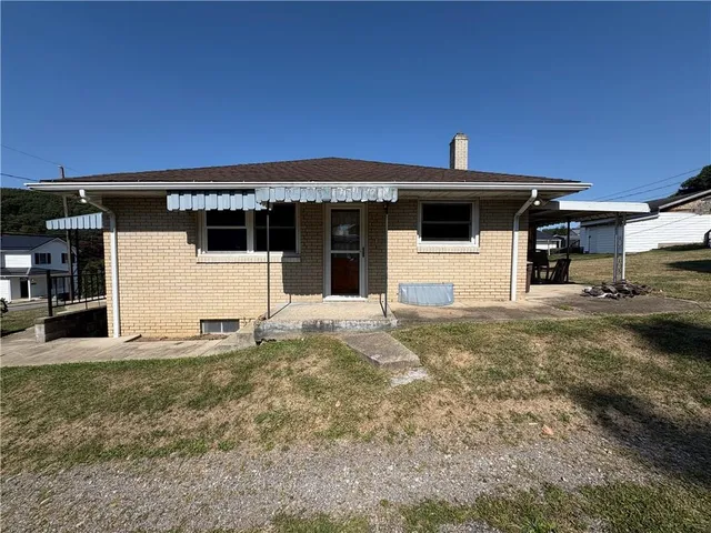 a view of a roof deck with couches chairs potted plants and a yard