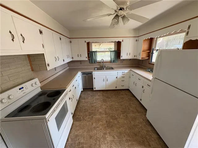 a kitchen with granite countertop a sink stove and refrigerator