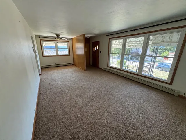 a view of an empty room with a window and bathroom