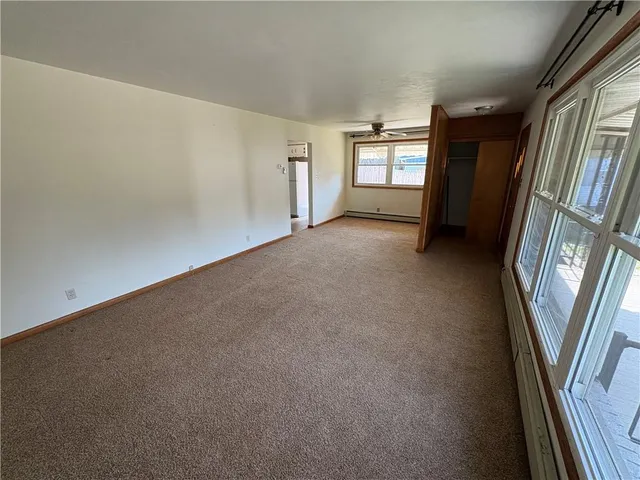 a view of an empty room with a window and closet area