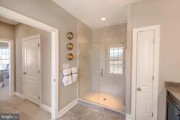 a bathroom with a glass shower door and a bathtub