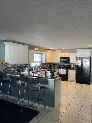 a kitchen with a table chairs stove and cabinets