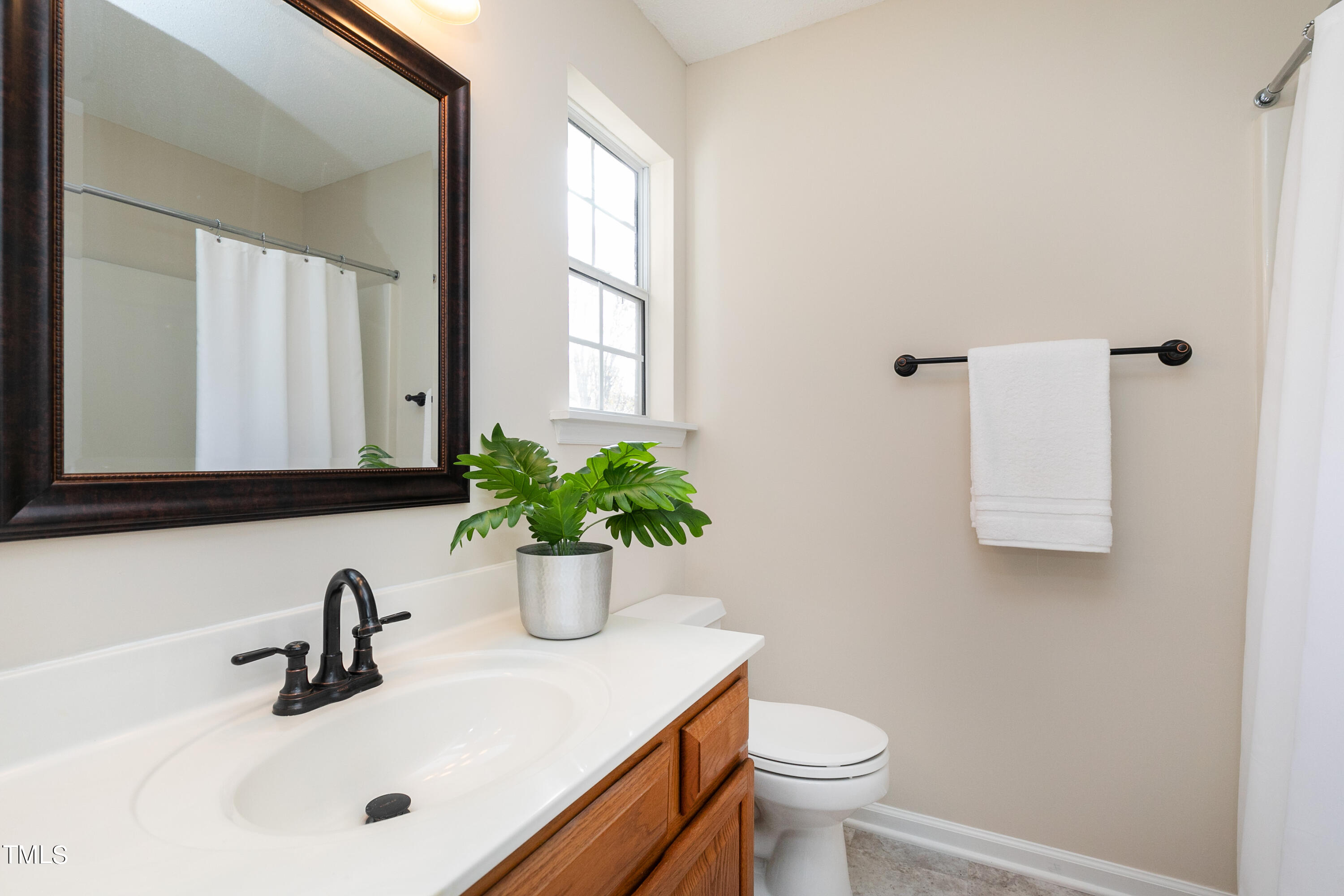 4414 Still Pines Drive Raleigh, NC 27613 - Photo 31 of 36 a bathroom with a sink a toilet and mirror