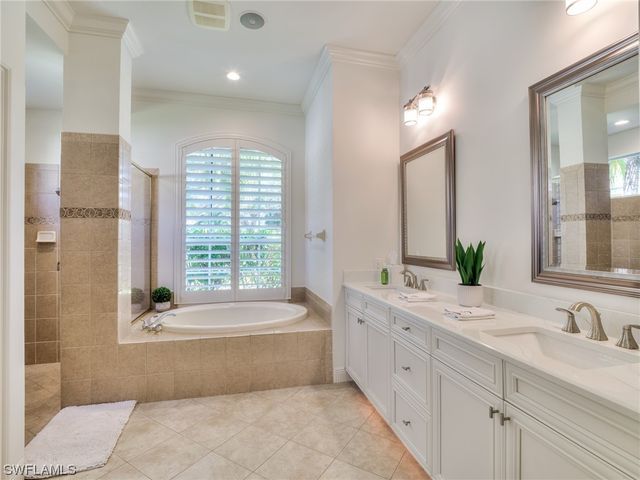 a white bath tub sitting in a bathroom next to a window