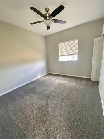 an empty room with a window and a fan