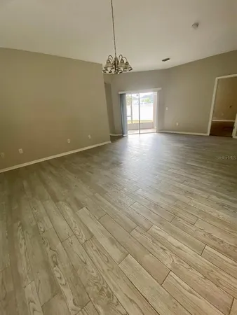 a view of a room with wooden floor and chandelier