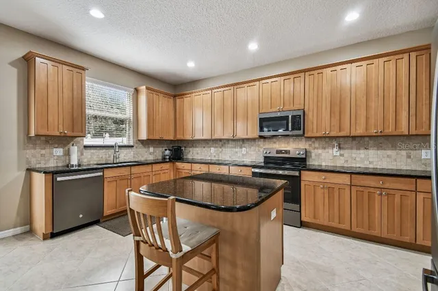 a kitchen with granite countertop wooden cabinets a stove top oven a sink and dishwasher