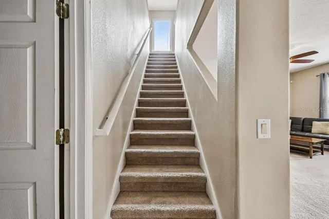 a view of staircase with lots of frames and chairs