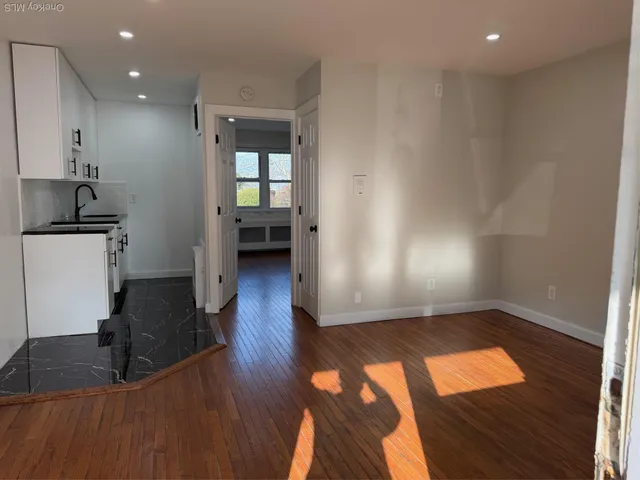 a living room with hard wood floors and a kitchen