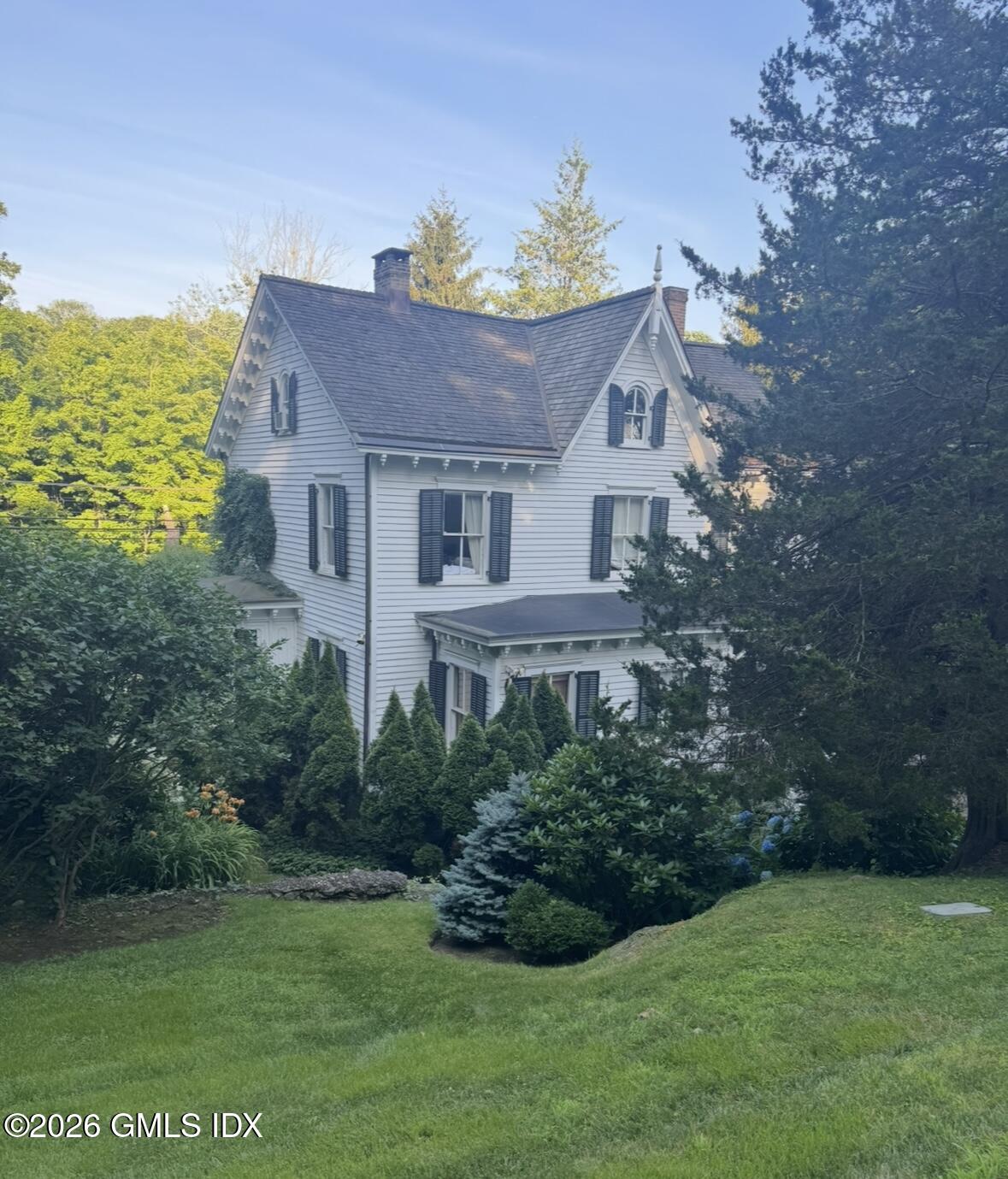 332 Riversville Road Greenwich, CT 06831 - Photo 4 of 22 a front view of a house with a garden
