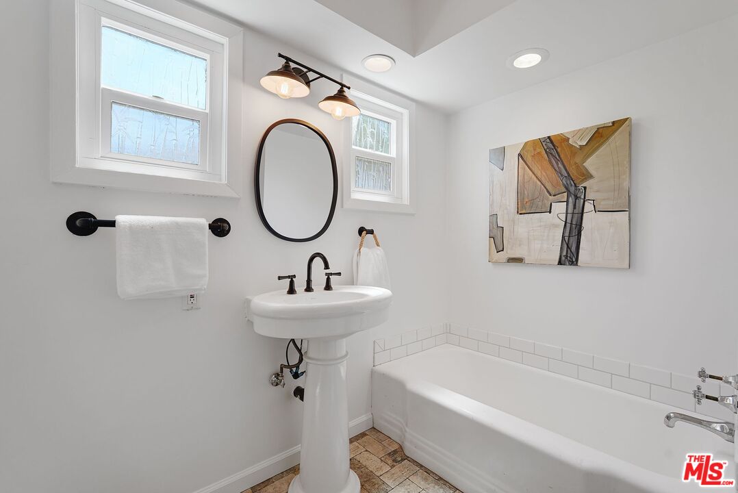 5350 Fallbrook Avenue Woodland Hills, CA 91367 - Photo 16 of 25 a bathroom with a sink a mirror and a bathtub