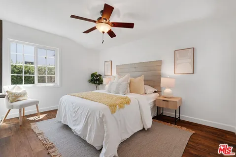 a bedroom with a bed and a painting on the wall