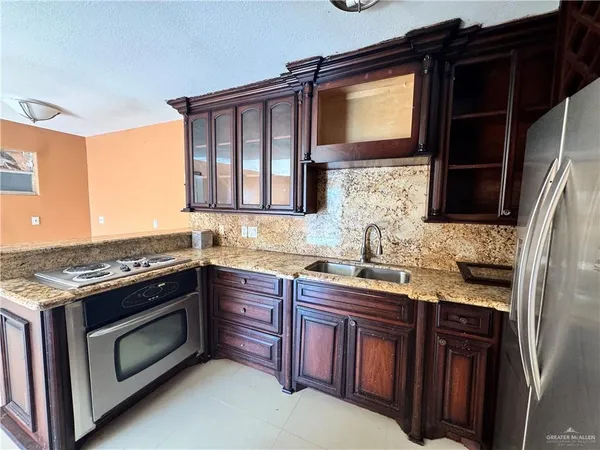 a kitchen with stainless steel appliances granite countertop a stove sink and cabinets