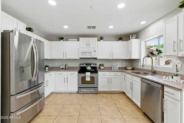 a kitchen with stainless steel appliances granite countertop a refrigerator sink and cabinets