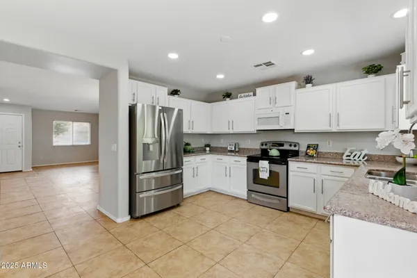a kitchen with stainless steel appliances granite countertop a refrigerator and a stove top oven