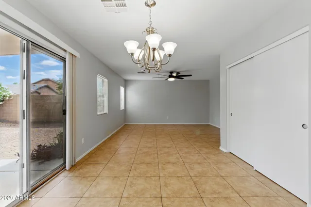 a view of a hallway with a chandelier fan and glass door