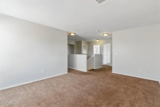 a view of a big room with wooden floor and windows