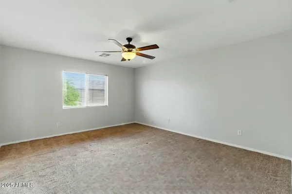 an empty room with a window and a fan