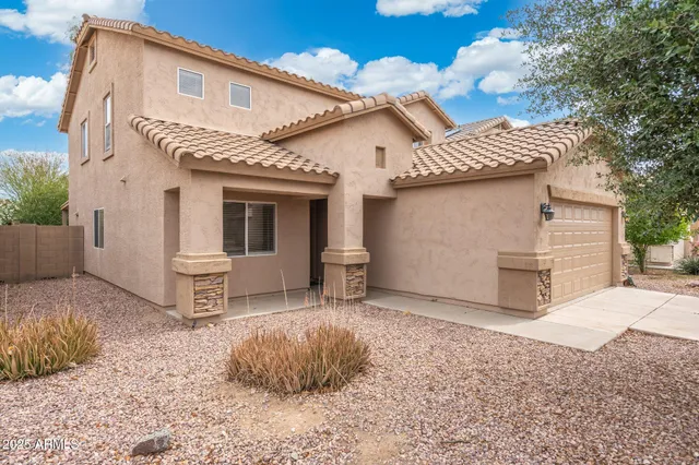 a backyard of a house with table and chairs