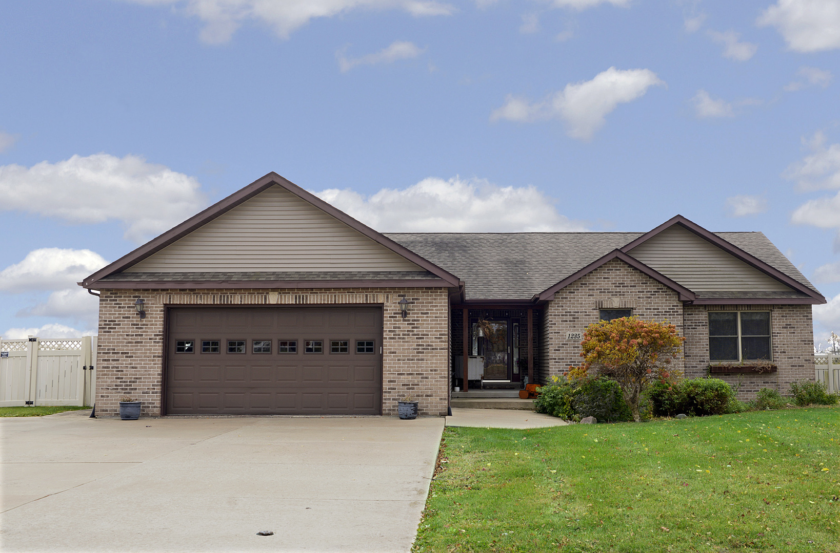 a front view of a house with a garden and yard