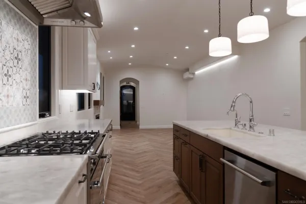 a kitchen with stainless steel appliances a sink stove and cabinets