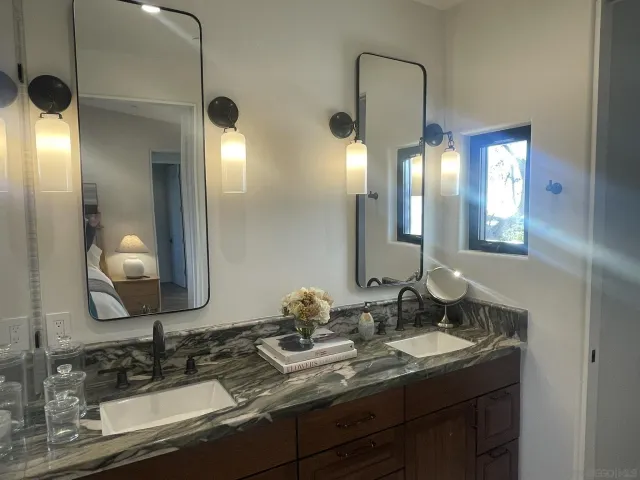 a bathroom with a double vanity sink and a mirror