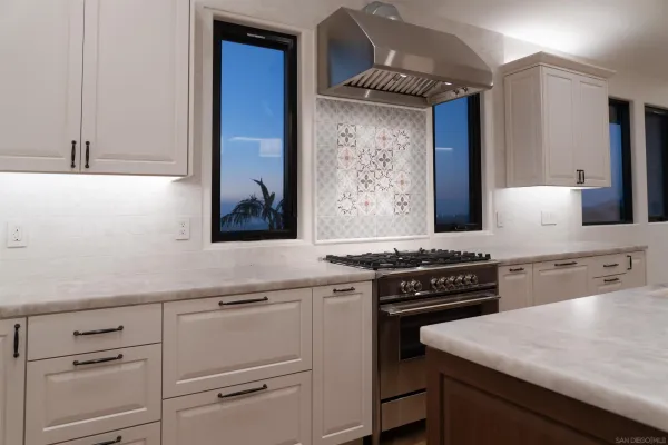 a kitchen with white cabinets and appliances