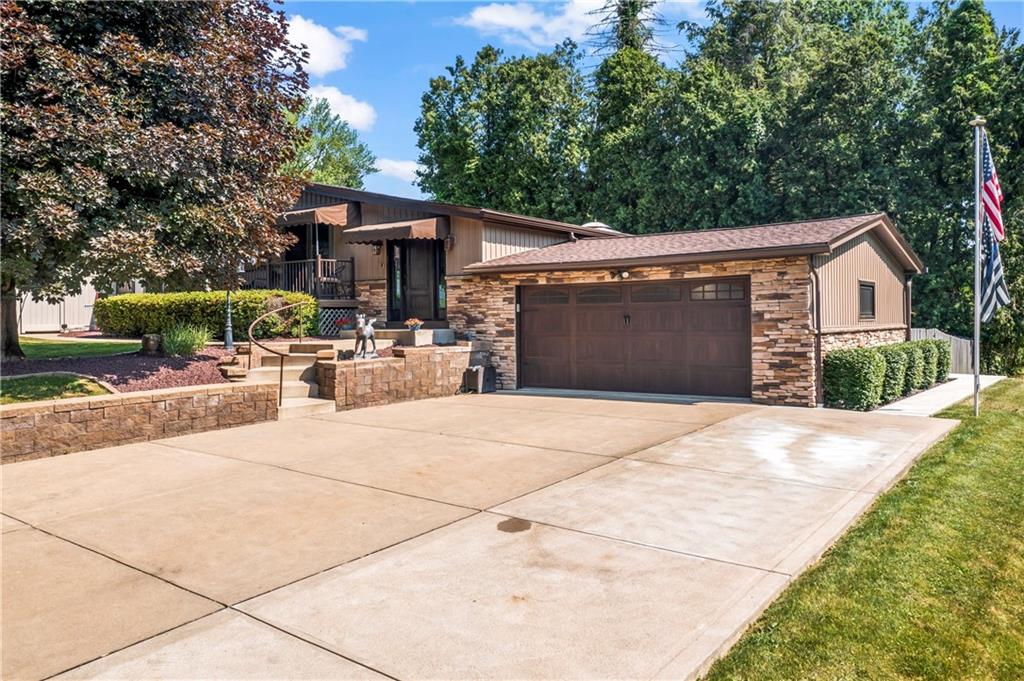 a front view of a house with trees and plants