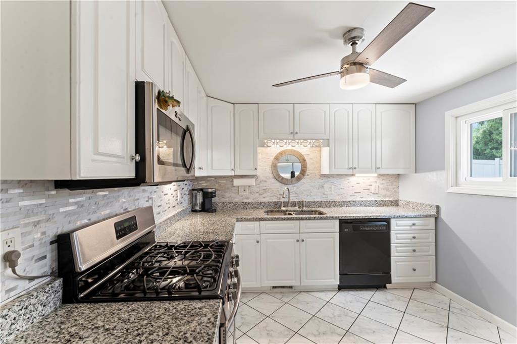 19 Ellen Drive McKees Rocks, PA 15136 - Photo 7 of 38 a kitchen with a sink stove and cabinets