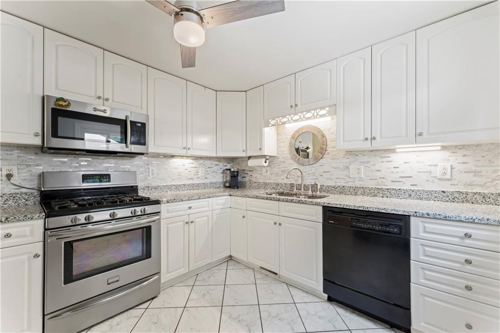 19 Ellen Drive McKees Rocks, PA 15136 - Photo 8 of 38 a kitchen with granite countertop a stove top oven microwave and cabinets