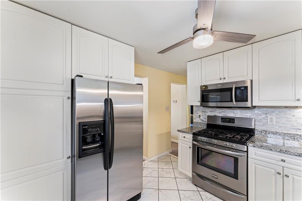 19 Ellen Drive McKees Rocks, PA 15136 - Photo 9 of 38 a kitchen with stainless steel appliances granite countertop a refrigerator a stove a microwave oven with white cabinets