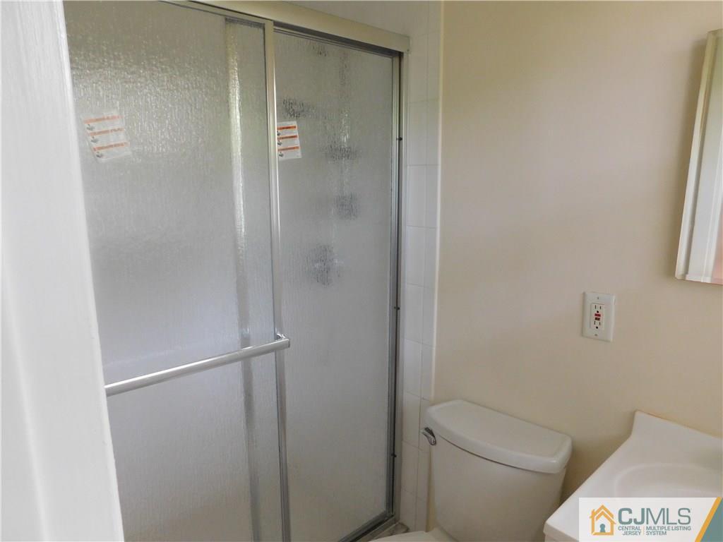 1 Perry Road East Brunswick, NJ 08816 - Photo 14 of 18 a bathroom with a granite countertop toilet and a shower