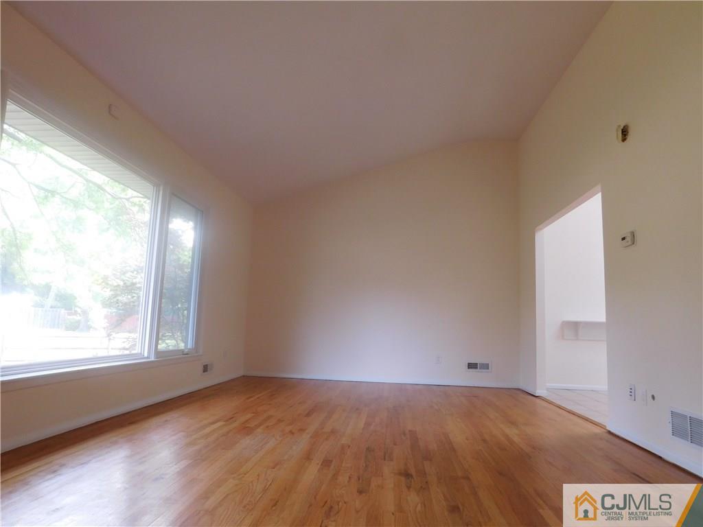1 Perry Road East Brunswick, NJ 08816 - Photo 8 of 18 an empty room with wooden floor and windows