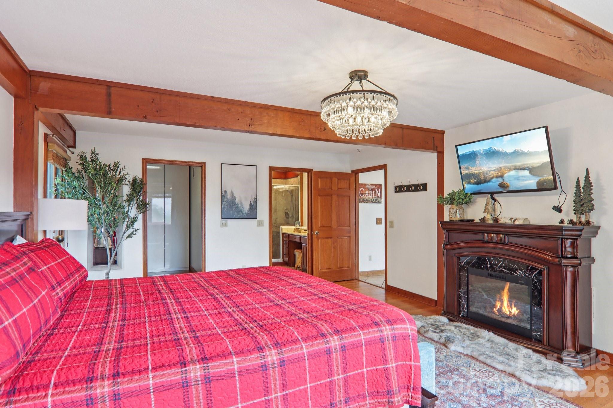 28 Nantahala Ridge Bryson City, NC 28713 - Photo 25 of 47 a large bedroom with a bed and a fireplace with a flat tv screen