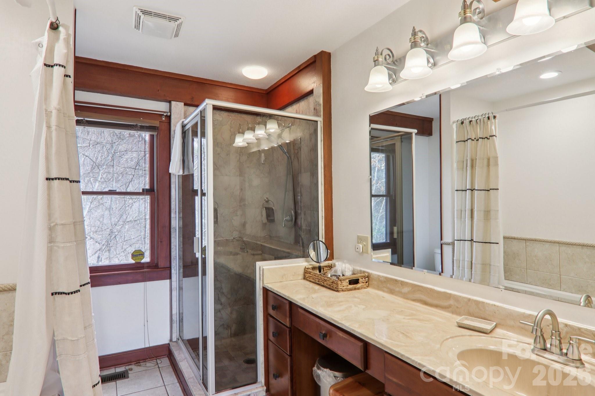 28 Nantahala Ridge Bryson City, NC 28713 - Photo 26 of 47 a bathroom with a granite countertop sink a mirror and a shower
