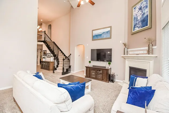 a living room with furniture a fireplace and a flat screen tv