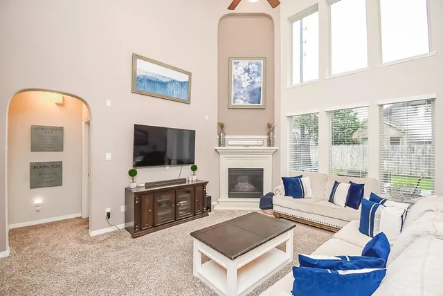 a living room with furniture a flat screen tv and a fireplace