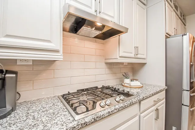 a stove top oven sitting inside of a kitchen