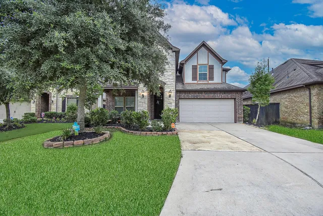a front view of a house with a yard and garage