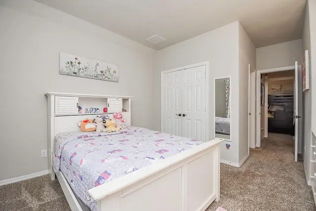 a bedroom with a bed and painting on the wall