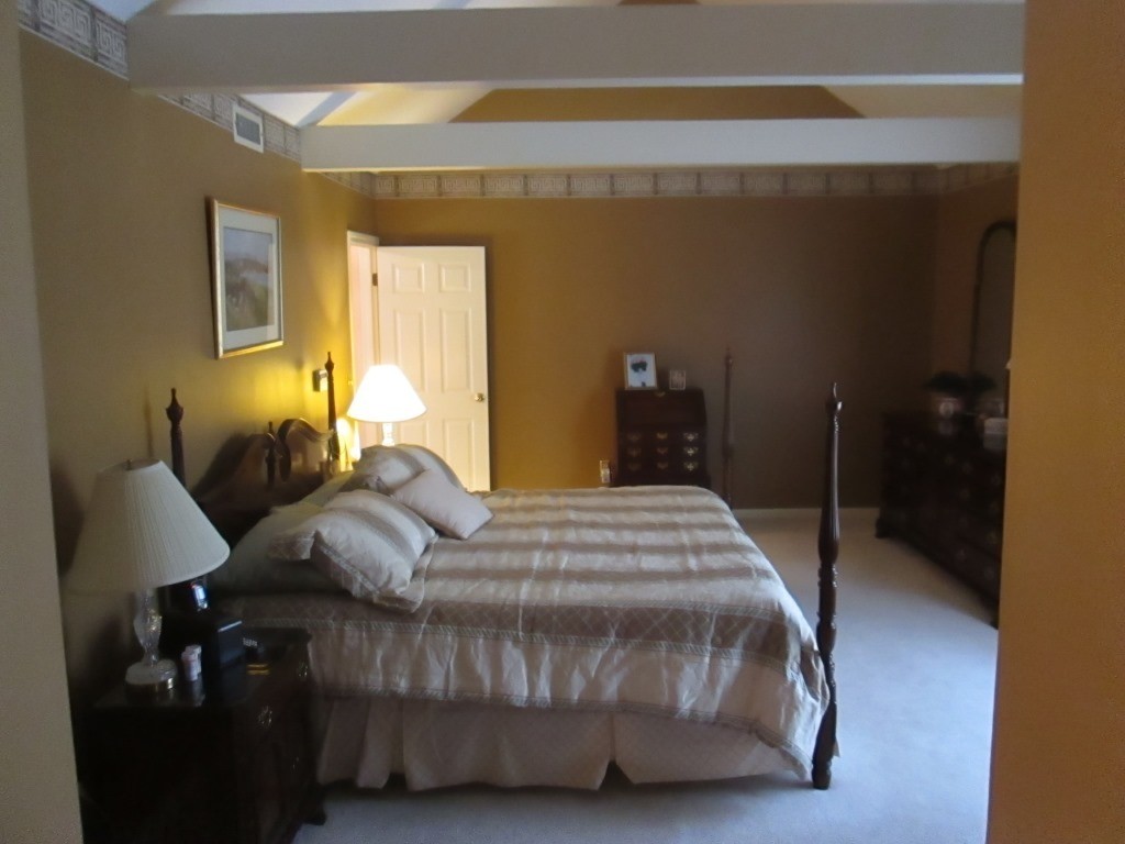 6 Holly Gate Circle, Unit 6 Middleton, MA 01949 - Photo 13 of 23 a bedroom with a bed and wooden floor