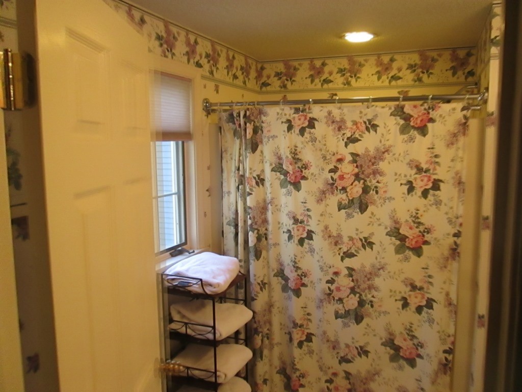 6 Holly Gate Circle, Unit 6 Middleton, MA 01949 - Photo 14 of 23 a bathroom with a shower curtain and a sink