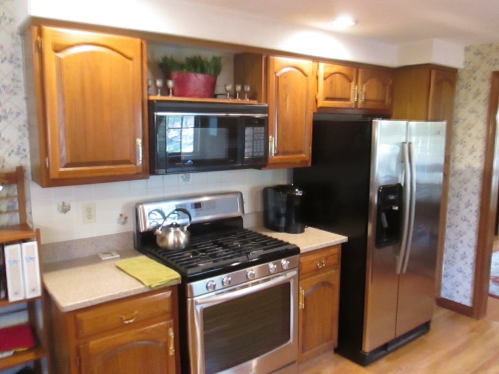 6 Holly Gate Circle, Unit 6 Middleton, MA 01949 - Photo 9 of 23 a kitchen with stainless steel appliances granite countertop a stove a refrigerator and a sink with wooden floor