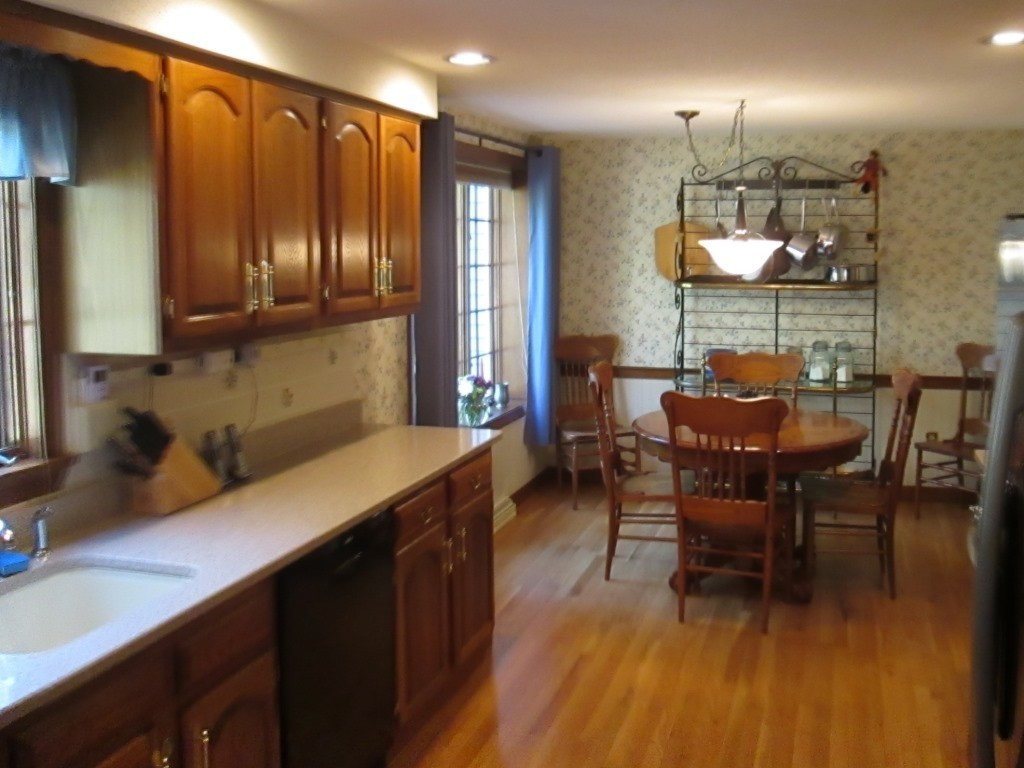 6 Holly Gate Circle, Unit 6 Middleton, MA 01949 - Photo 10 of 23 a kitchen with a dining table chairs cabinets a sink and appliances