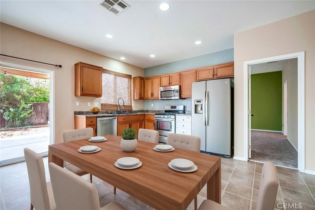 33409 Mesolite Way Menifee, CA 92584 - Photo 5 of 18 a kitchen with furniture and a refrigerator