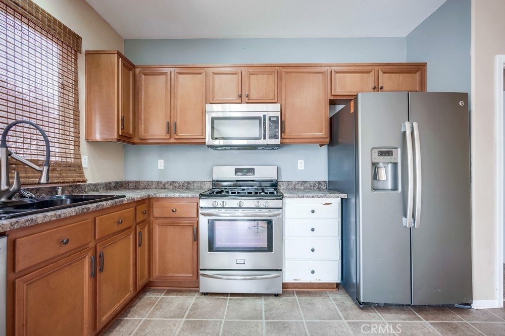 33409 Mesolite Way Menifee, CA 92584 - Photo 6 of 18 a kitchen with stainless steel appliances granite countertop a refrigerator stove and sink