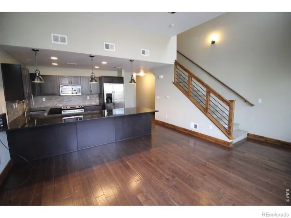 a view of kitchen and living room with wooden floor