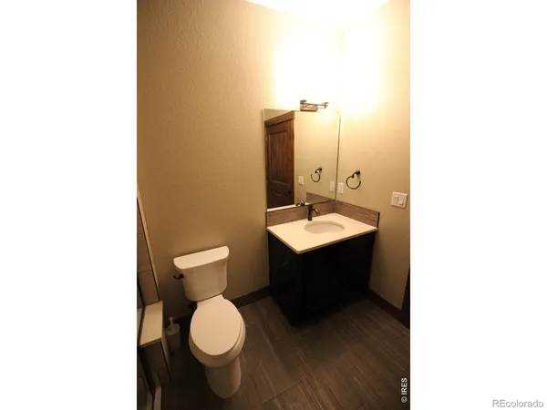 a bathroom with a toilet a sink and mirror