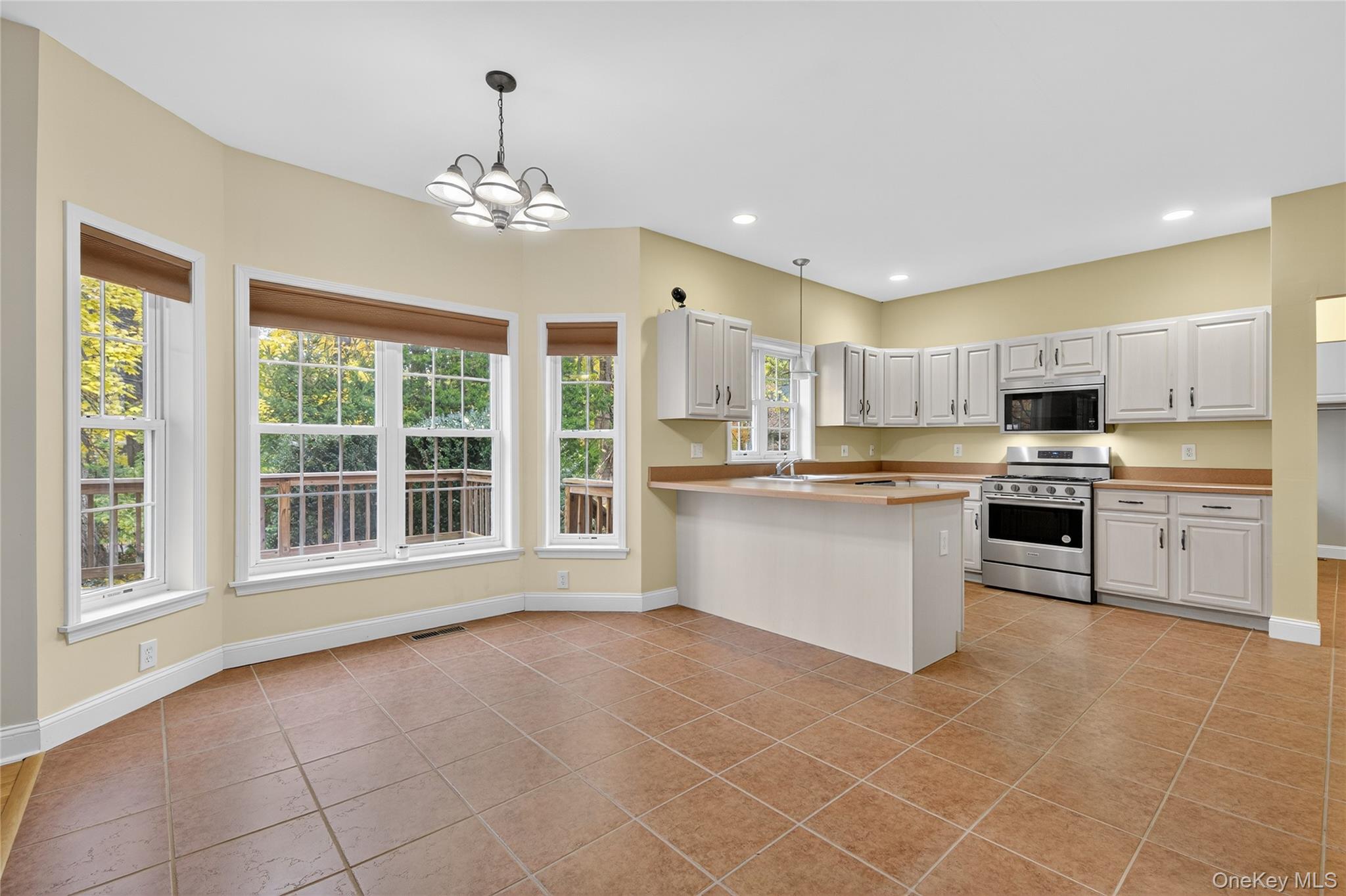 9 Exeter Circle Beacon, NY 12508 - Photo 12 of 41 a large kitchen with kitchen island a stove a sink dishwasher and white cabinets with wooden floor