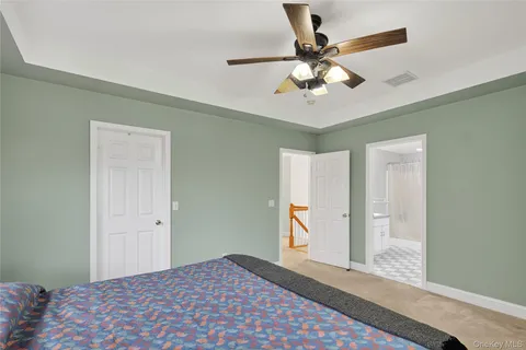 a spacious bathroom with a granite countertop sink a mirror and a shower